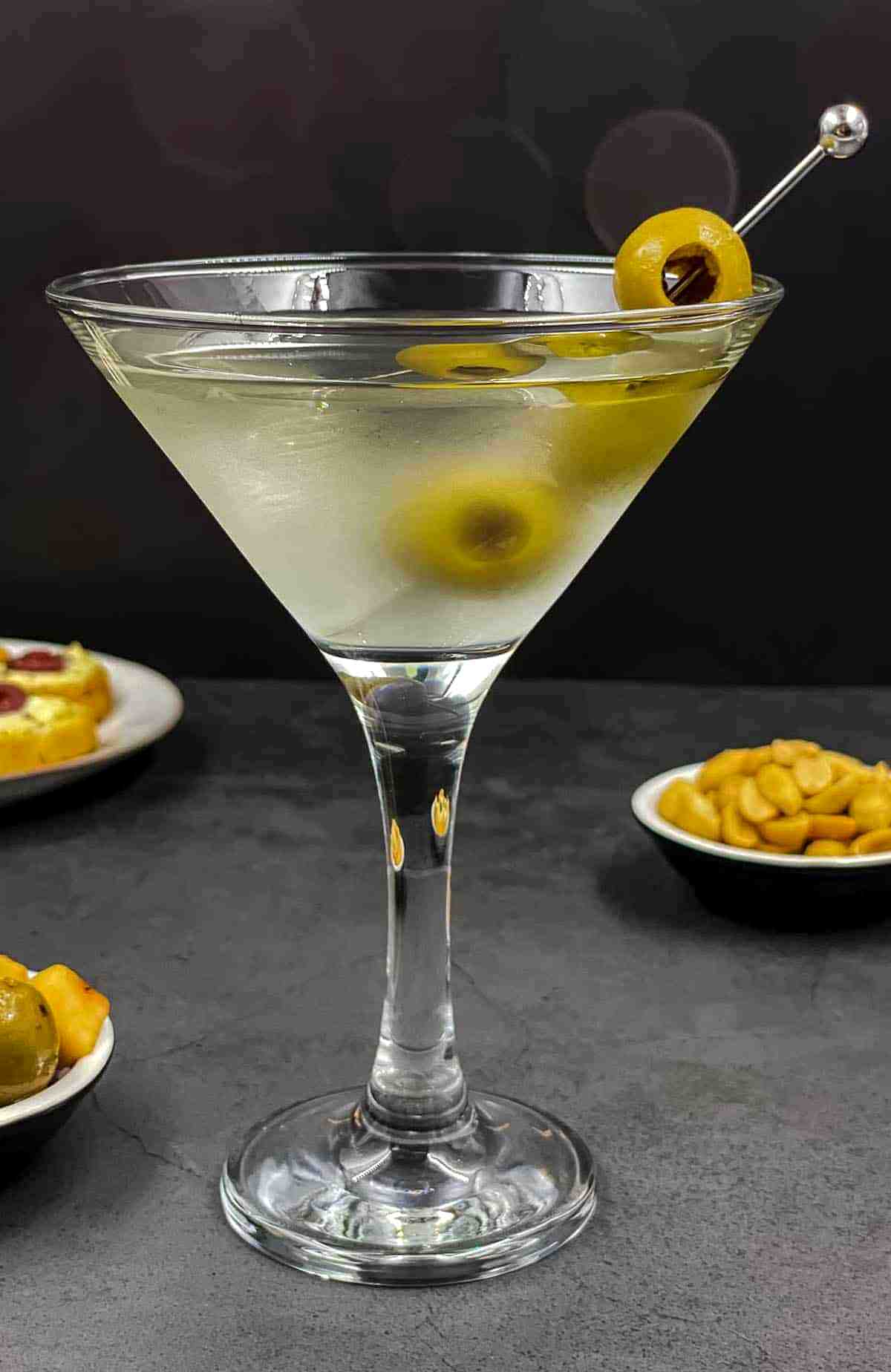 Dirty Martini cocktail in a martini glass with green olives